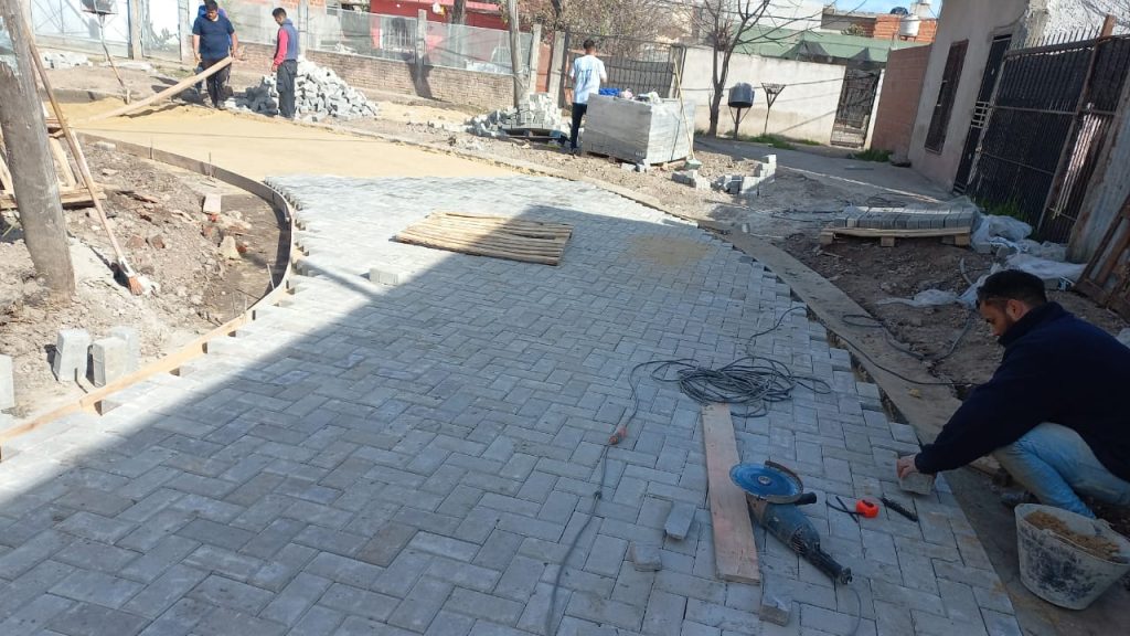 Ajuste y nivelado final de adoquines en obra vial en calle residencial