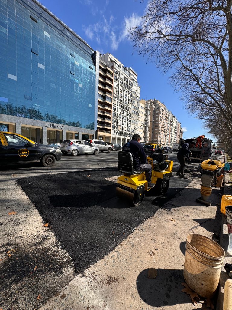 Compactadora vibratoria trabajando sobre carpeta asfáltica en vía urbana