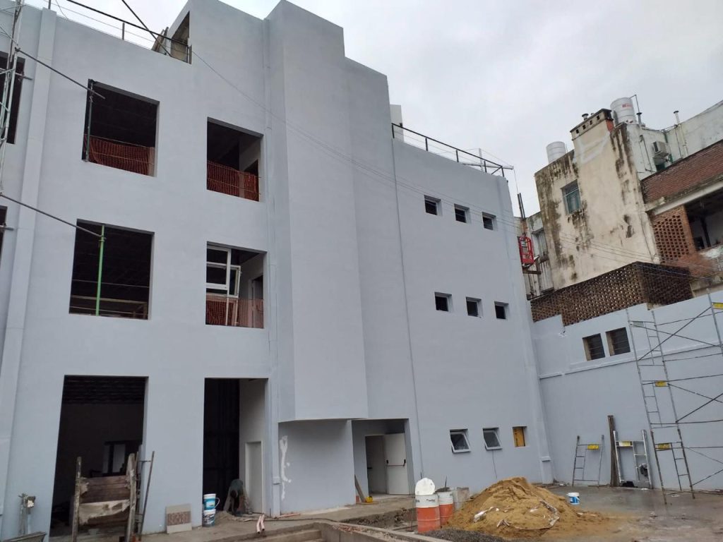 Construcción de edificio con obra exterior en curso