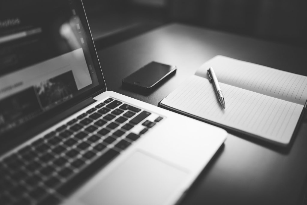 Formulario de contacto online abierto en portátil con libreta y bolígrafo